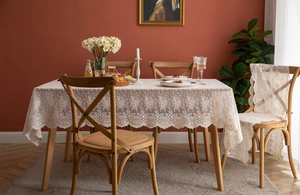 Détail d'une nappe en dentelle blanche avec bords festonnés et motifs floraux au crochet