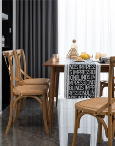 Detail of modern black and white jacquard table runner with bold typography on dark wood table