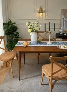 Chemin de table bleu à motifs poissons et glands blancs sur une table en bois foncé