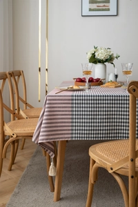 Detail of pink stripes and grey plaid tablecloth with elegant white fringe tassels