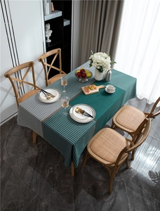 Detail of green tablecloth with houndstooth pattern and stripes on wooden table
