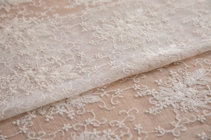 Gros plan de la broderie florale en dentelle blanche sur tulle pour décoration de mariage