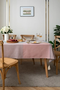 Detail of pink and gray jacquard table cloth featuring elegant white fringe tassels