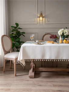 Detailed texture of jacquard houndstooth tablecloth with elegant fringe tassels in a room