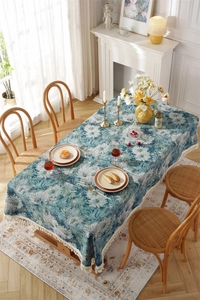 Close-up of vintage blue daisy jacquard tablecloth with elegant off-white tassel trim