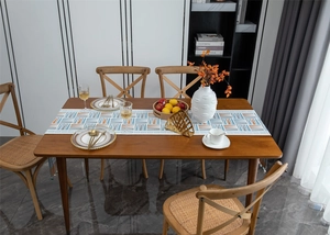 Detail of modern chenille table runner featuring blue and orange geometric patterns and tassels