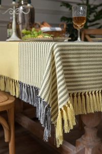 Close-up of woven houndstooth tablecloth with long yellow and black decorative tassels