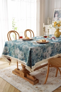 Detail of vintage floral jacquard tablecloth with elegant beige fringe tassel edges