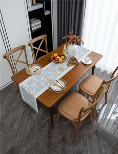 Modern geometric chenille table runner with blue and orange patterns and white tassels