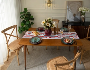 Close-up of jacquard table runner with red geometric letters and elegant white tassels