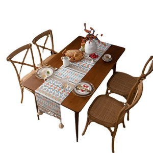 Bohemian geometric table runner with colorful cotton tassels on a dark wood dining table
