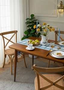 Detail of French vintage dining chair with X-back and woven rattan seat in cozy home setting