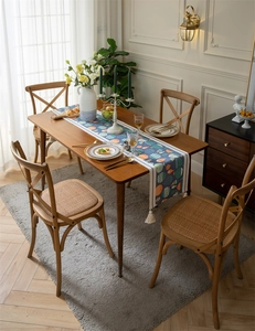 Détail du chemin de table bleu avec poissons et pompons en coton sur une table en bois