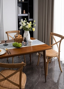 Detailed view of the walnut wood dining table leg with elegant gold metal cap tip