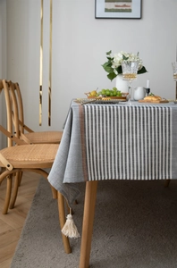 Detail of modern striped tablecloth with beige tassels and textured jacquard fabric