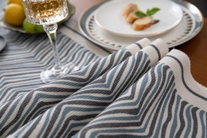 Detail of blue and grey geometric wave weave fabric with cotton tassel fringe texture