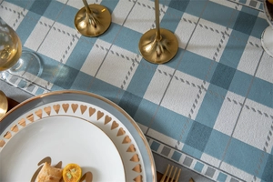 Detail of blue and white checkered table runner on a dark wood table with gold decor