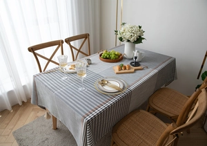 Detail of grey geometric jacquard table runner with tassel trim and woven line pattern