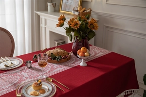 Primer plano de mantel jacquard rojo con motivos florales blancos vintage y borlas finas