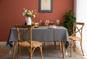 Detail of woven jacquard stripe pattern and soft tassel edges on a grey tablecloth