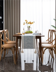 Detail of blue and white herringbone weave table runner with cotton tassel accents