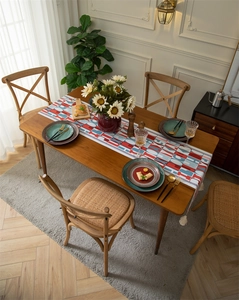 Macro detail of red letter jacquard table runner with decorative white side tassels
