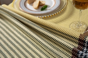 Detailed view of yellow and black houndstooth tablecloth with woven fabric texture