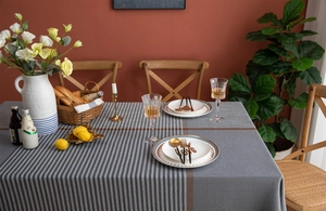 Detail of grey houndstooth tablecloth texture with thick tassels and stripe accents