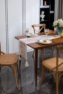 Dettaglio di runner da tavolo geometrico colorato con spesse nappe in cotone bianco