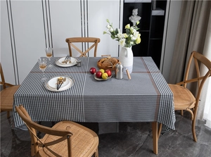 Polyester houndstooth and plaid tablecloth on wooden dining table with tableware