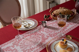 Primer plano del mantel de jacquard rojo con camino de mesa floral blanco y textura tejida