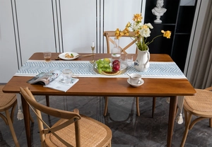 Close-up of chevron pattern table runner with tassels on a wooden dining table