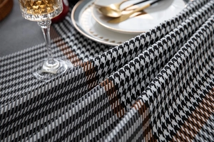 Close-up of houndstooth tablecloth texture with elegant glassware and dining set