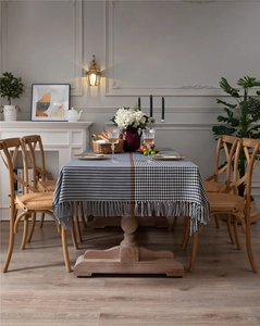 Detail of black and white houndstooth tablecloth with orange stripes and fringe trim