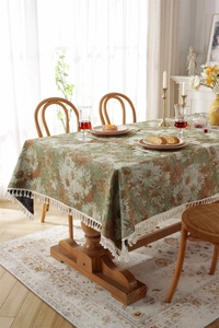Detail of vintage jacquard floral tablecloth with white daisies and fringe edges