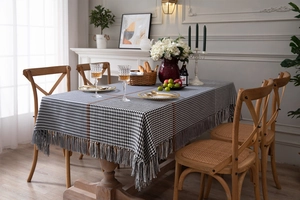 Detail showing the thick hounds-tooth jacquard texture and fringe edges of the tablecloth