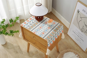 Detail of multi-functional cover cloth with geometric patterns and white fringe tassels
