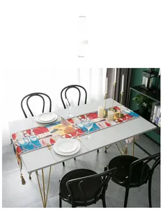 Detail of red jacquard table runner with abstract pattern and fringe tassels on a dining table