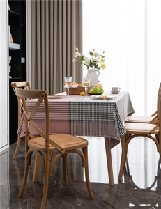 Detail of pink and black houndstooth plaid tablecloth in a cozy home dining room setting