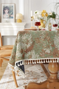 Detail of vintage floral jacquard tablecloth with elegant white fringe tassels on edges