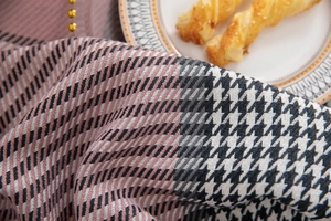 Detail of pink houndstooth tablecloth fabric with elegant golden bead embellishments