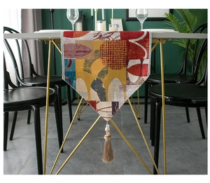 Detail of modern jacquard table runner featuring geometric patterns and beaded tassel fringe