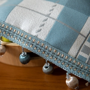 Modern geometric blue checkered table runner with elegant beaded tassel fringe detail