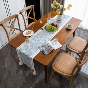 Blue and white chevron table runner with tassels on a dark wood dining table