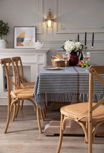 Detail of modern houndstooth tablecloth with orange stripe and elegant grey fringe accents