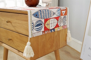 Detail of colorful jacquard dust cover featuring cartoon fish patterns and white tassels
