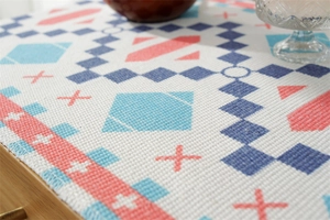 Macro shot of geometric print fabric with cross-stitch patterns on a side table cover
