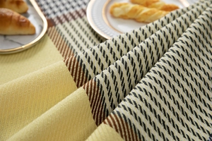 Detailed close-up of yellow houndstooth woven fabric on a cozy dining table setting