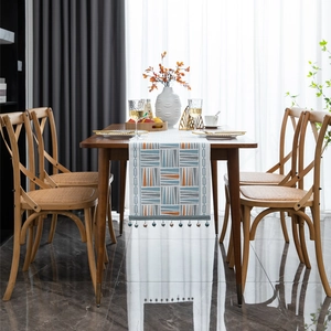 Modern geometric chenille table runner with colorful patterns and pompom tassels decor