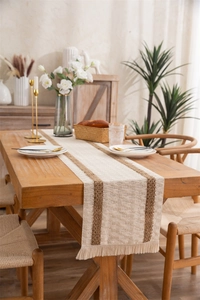 Close-up of woven cotton linen table runner with brown stripes and handmade tassels